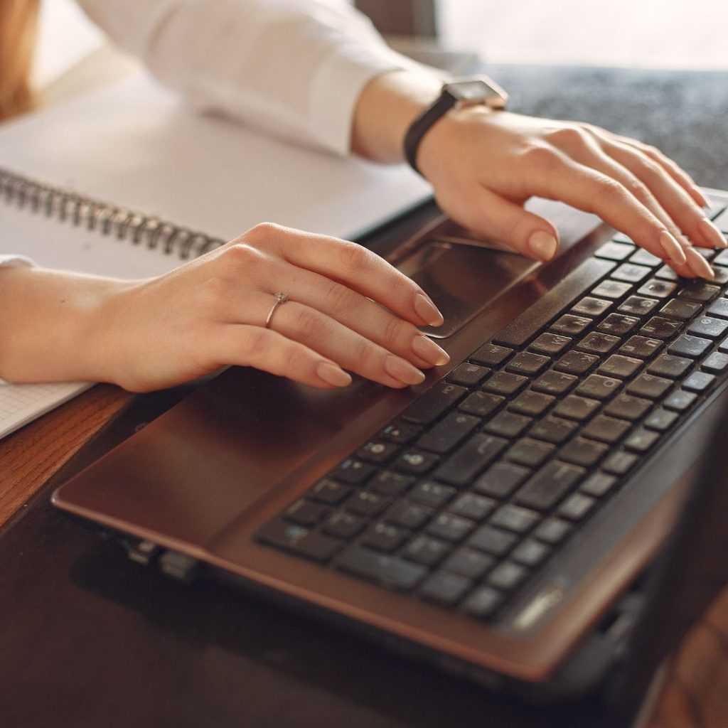 person with hands typing on computer