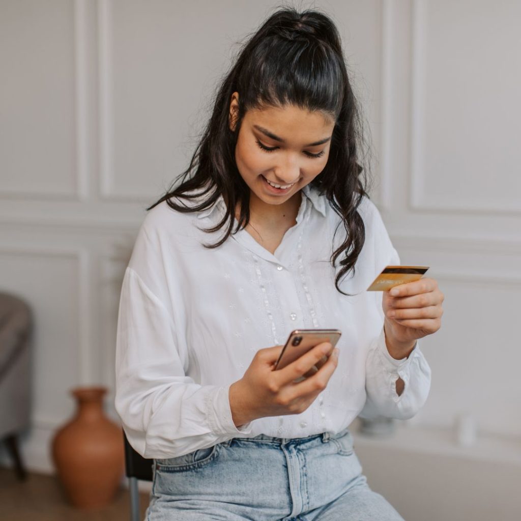 person holding credit card while shopping on mobile device