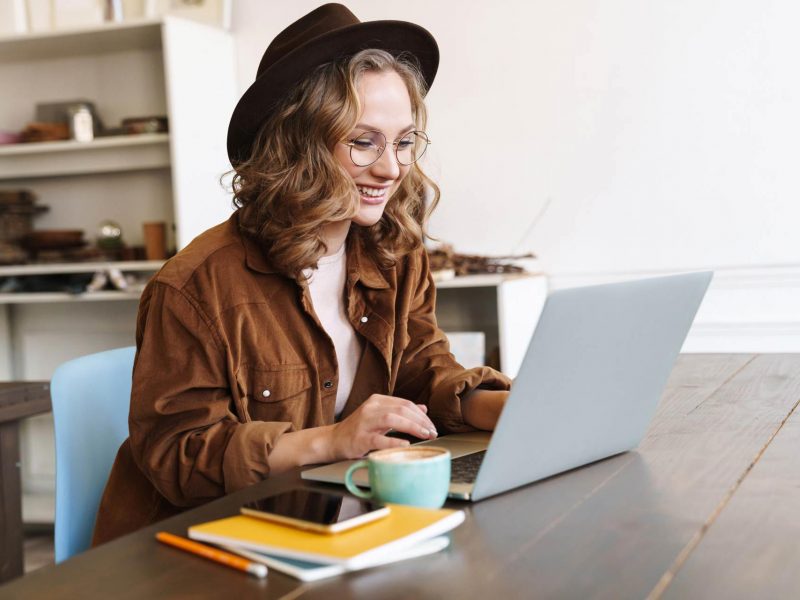 image-of-cheerful-woman-working-with-laptop-while-CNX4RJP.jpg